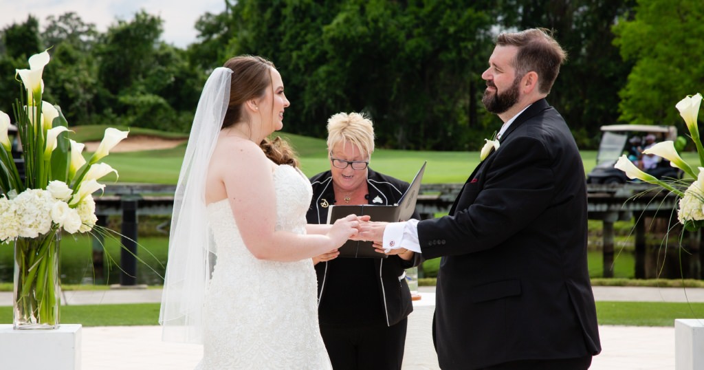Putting the wedding ring on my husband's finger during the ceremony. (Photo by David and Vicki Photography)